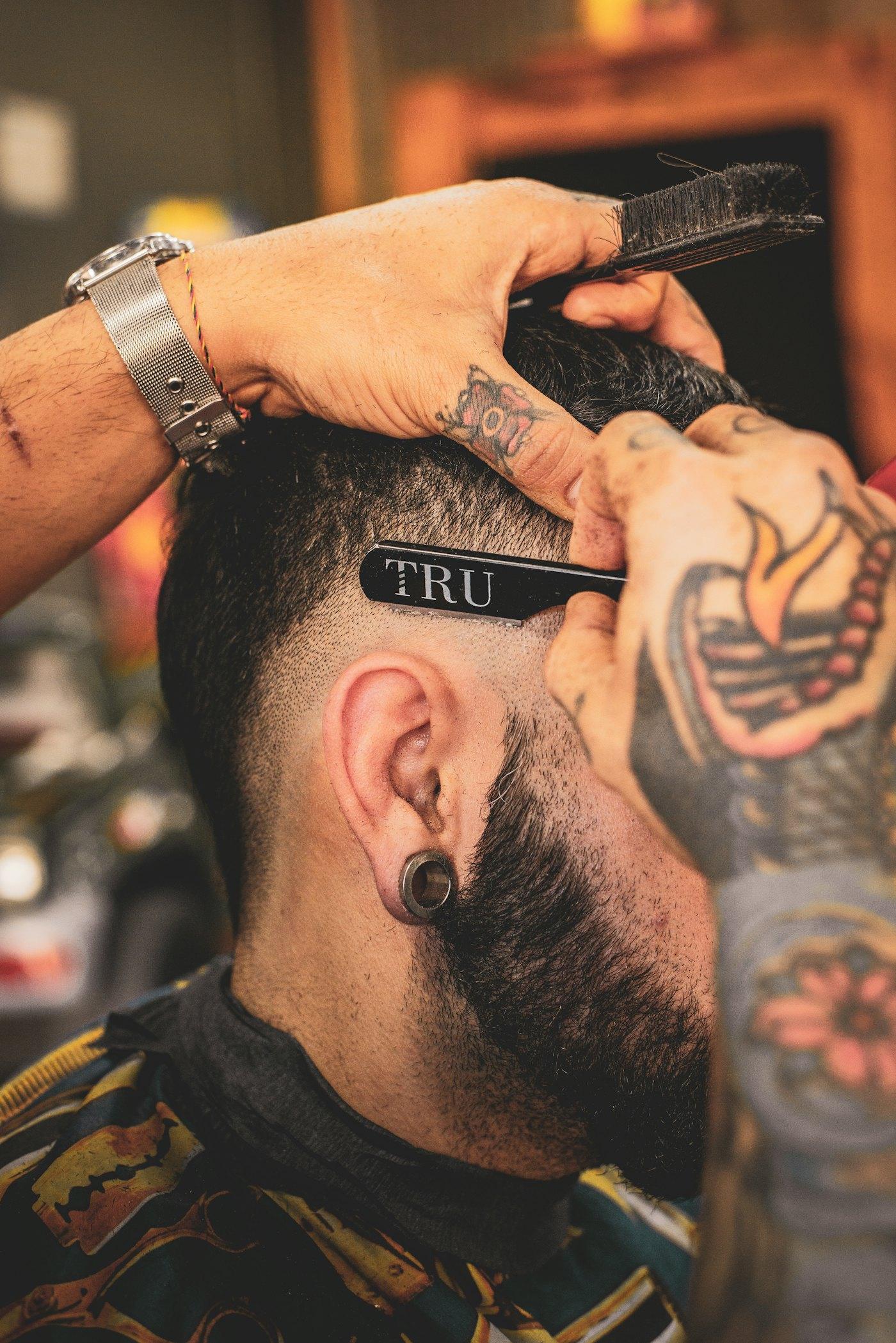 Barber finishing a precision fade with clippers