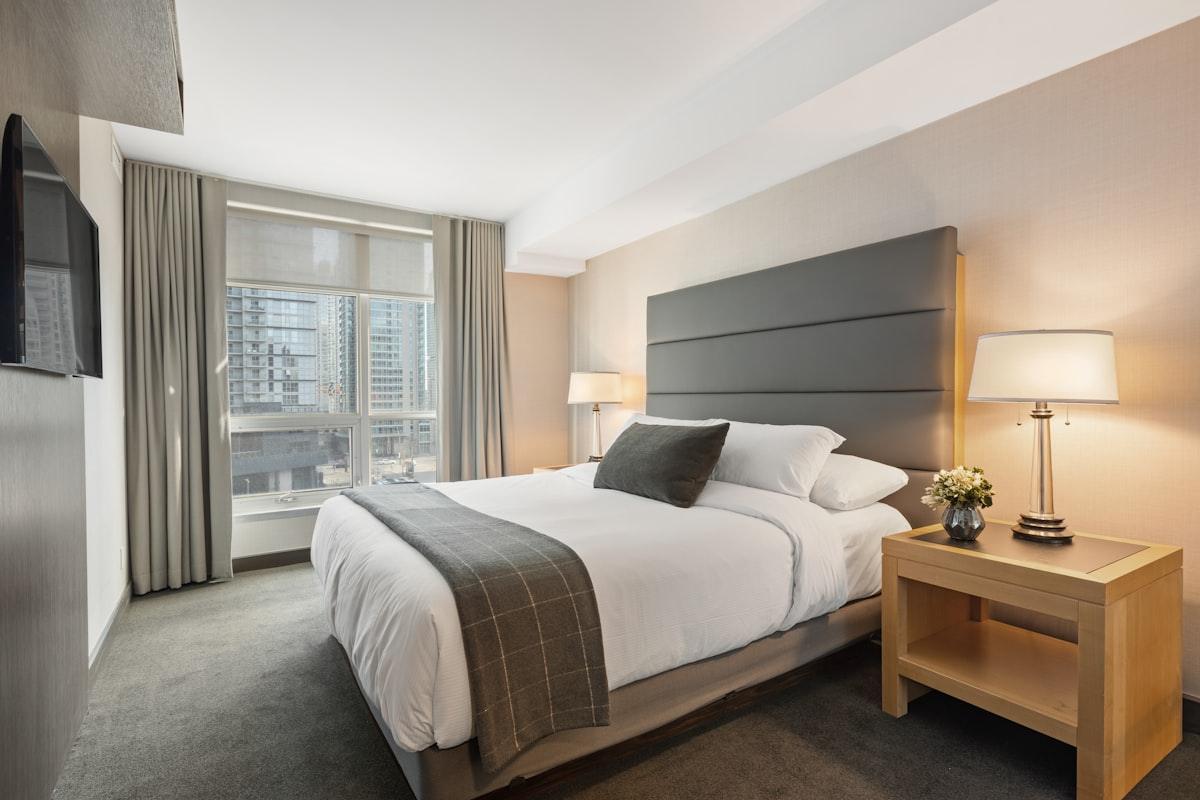 Muhabura suite: king bed against a quiet grey wall