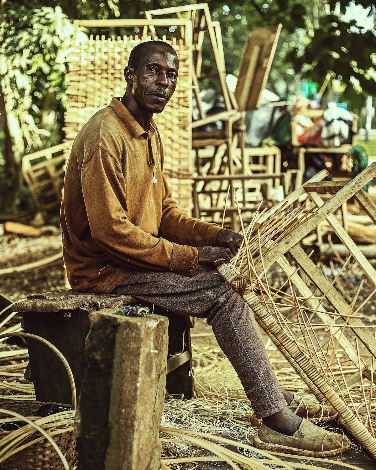 An artisan weaving cane by hand at the co-operative workshop
