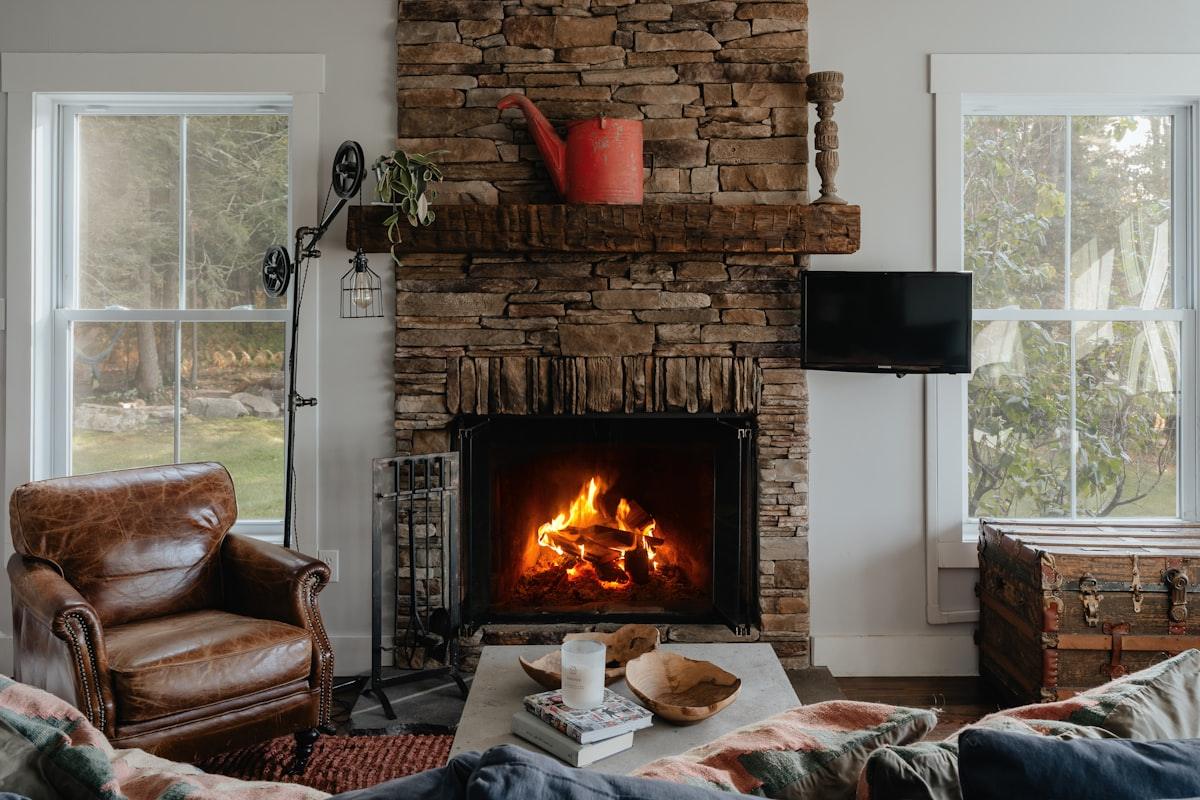 The long room: a low stone hearth with the fire burning, armchairs pulled close