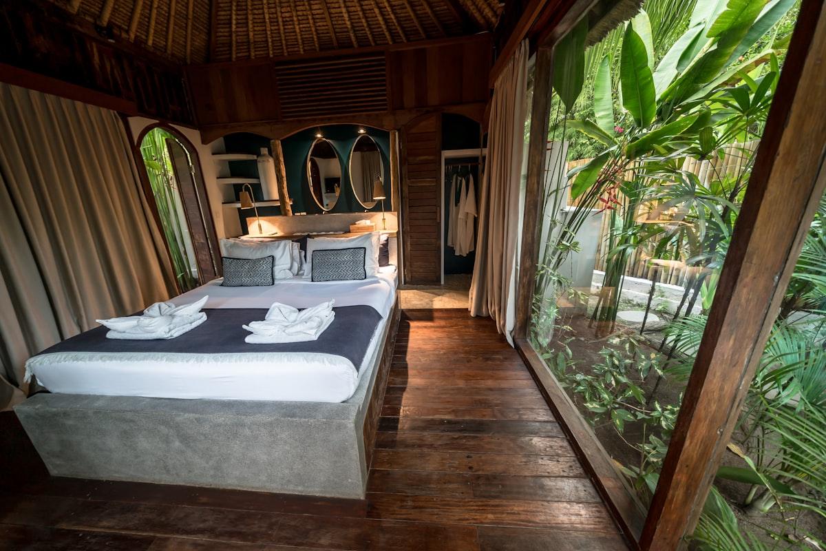 Bisoke suite: bed beside a wide window opening onto the garden